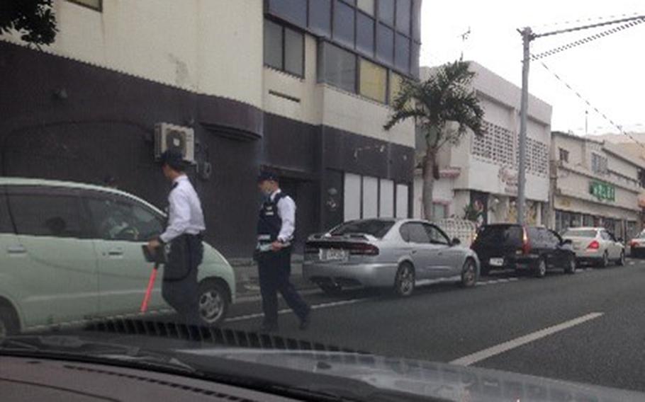 Policemen are checking illegally parked cars.